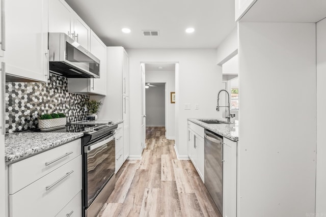 301 Kings Row Dr Unit 106, Little Rock, AR 72207 - kitchen featuring appliances with stainless steel finishes, light wood-style floors, backsplash, white cabinets, and recessed lighting