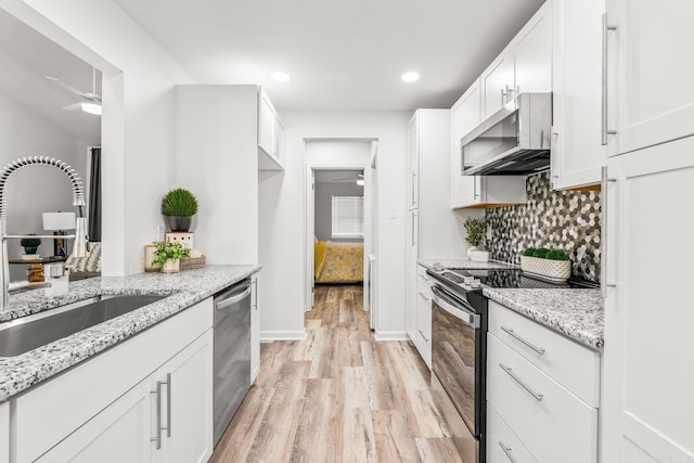 301 Kings Row Dr Unit 106, Little Rock, AR 72207 - kitchen featuring stainless steel appliances, light wood-style flooring, a ceiling fan, white cabinets, and decorative backsplash