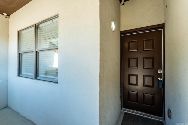 301 Kings Row Dr Unit 106, Little Rock, AR 72207 - view of exterior entry featuring stucco siding and a security system