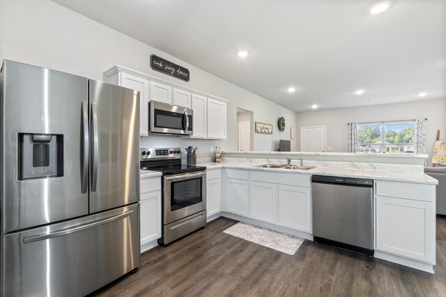 1040 Gallery Dr, Conway, AR 72032 - kitchen featuring appliances with stainless steel finishes, a peninsula, white cabinets, dark wood-style flooring, and recessed lighting
