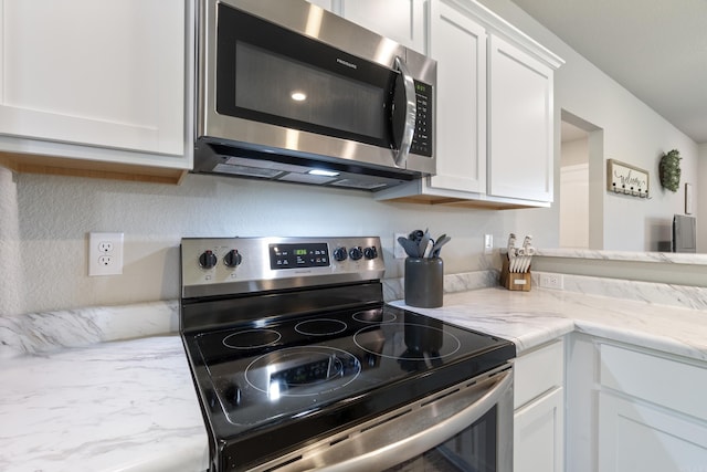 1040 Gallery Dr, Conway, AR 72032 - kitchen featuring appliances with stainless steel finishes, white cabinetry, and light stone countertops