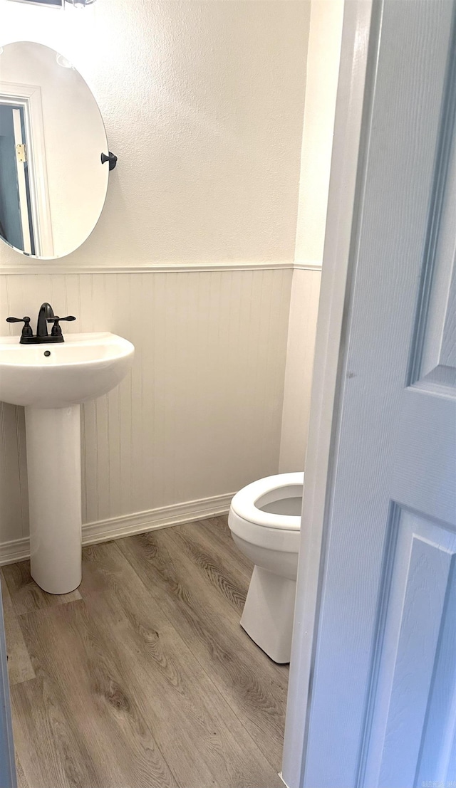 702 Polk Road 57, Mena, AR 71953 - bathroom with wood finished floors and wainscoting