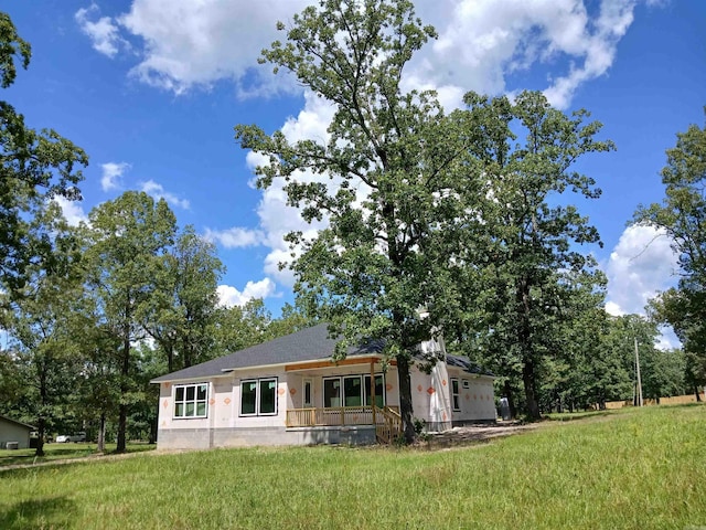 view of front of home featuring a front yard, covered porch, and stucco siding