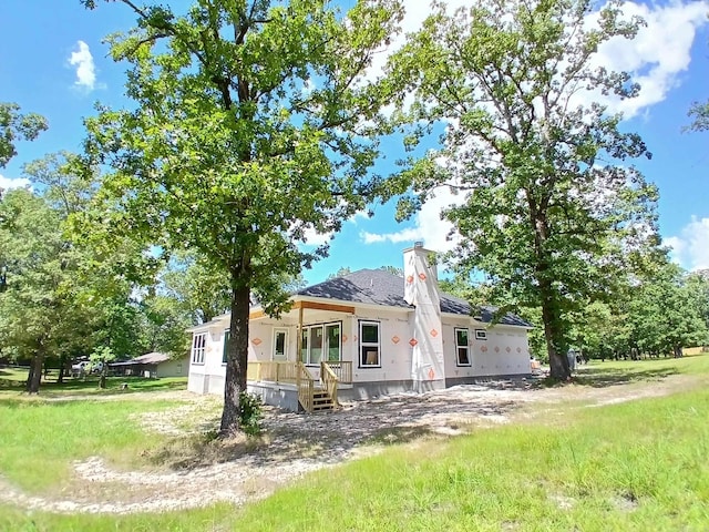 back of house featuring roof with shingles