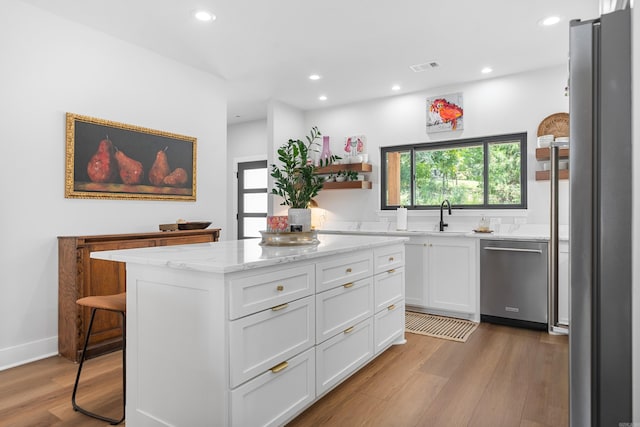 1113 Twin Points Rd, Hot Springs, AR 71913 - kitchen featuring appliances with stainless steel finishes, light wood-style floors, white cabinets, recessed lighting, and light stone counters