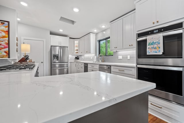 1113 Twin Points Rd, Hot Springs, AR 71913 - kitchen with appliances with stainless steel finishes, tasteful backsplash, white cabinetry, light stone counters, and glass insert cabinets