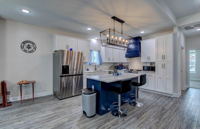 226 Shamsie Ln, White Hall, AR 71602 - kitchen featuring appliances with stainless steel finishes, premium range hood, light wood-style floors, a kitchen island, and white cabinets
