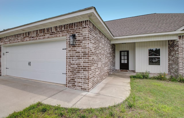 226 Shamsie Ln, White Hall, AR 71602 - view of exterior entry featuring brick siding, a shingled roof, and an attached garage