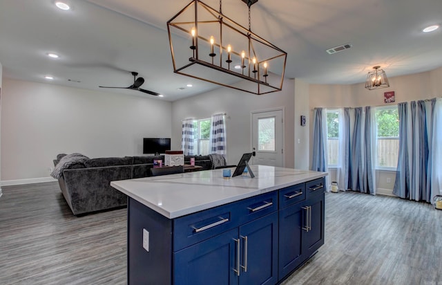 226 Shamsie Ln, White Hall, AR 71602 - kitchen with blue cabinets, wood finished floors, plenty of natural light, a kitchen island, and recessed lighting