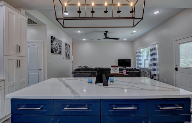 226 Shamsie Ln, White Hall, AR 71602 - kitchen with blue cabinets, open floor plan, white cabinetry, ceiling fan, and a center island