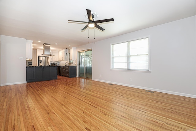 1913 Topf Rd, North Little Rock, AR 72116 - unfurnished living room featuring a ceiling fan and light wood finished floors