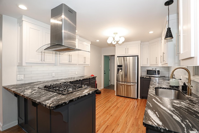 1913 Topf Rd, North Little Rock, AR 72116 - kitchen featuring stainless steel appliances, island range hood, dark stone countertops, white cabinets, and a peninsula
