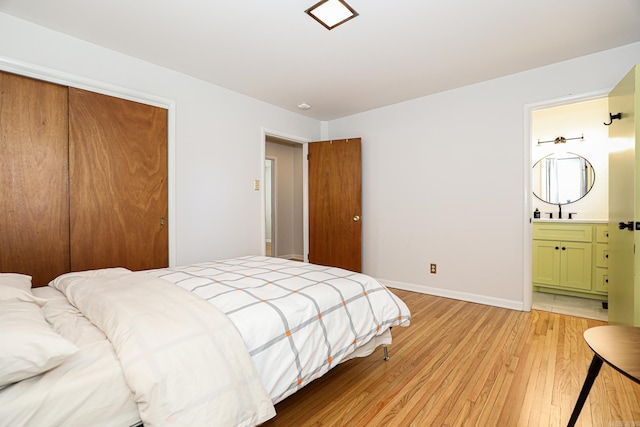 1913 Topf Rd, North Little Rock, AR 72116 - bedroom with light wood-style flooring, a closet, and ensuite bathroom