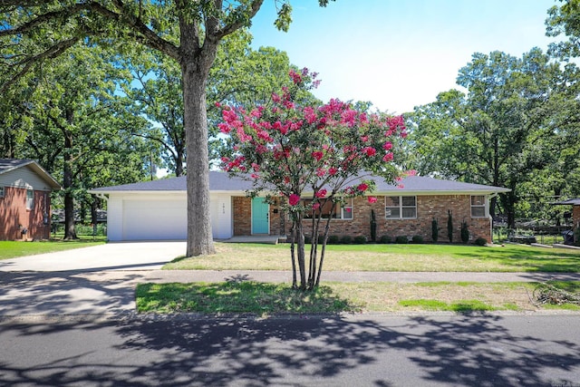 1913 Topf Rd, North Little Rock, AR 72116 - view of front of house featuring concrete driveway, a garage, brick siding, and a front lawn