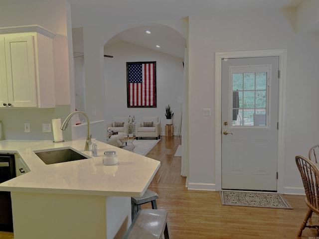 3 Timber Ridge Cir, Arkadelphia, AR 71923 - kitchen with light wood-type flooring, light countertops, white cabinetry, arched walkways, and lofted ceiling