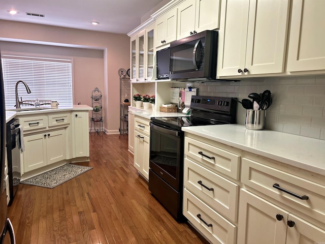 3 Timber Ridge Cir, Arkadelphia, AR 71923 - kitchen with black appliances, decorative backsplash, light countertops, dark wood-type flooring, and glass insert cabinets