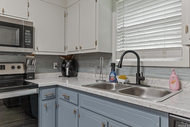 508 Cindy St, Paragould, AR 72450 - kitchen featuring appliances with stainless steel finishes, light countertops, decorative backsplash, and white cabinetry