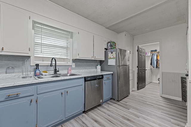 508 Cindy St, Paragould, AR 72450 - kitchen with appliances with stainless steel finishes, blue cabinets, light wood-style floors, light countertops, and white cabinetry