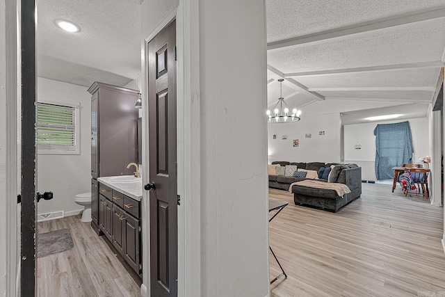 508 Cindy St, Paragould, AR 72450 - corridor featuring a textured ceiling, light wood-type flooring, and a chandelier