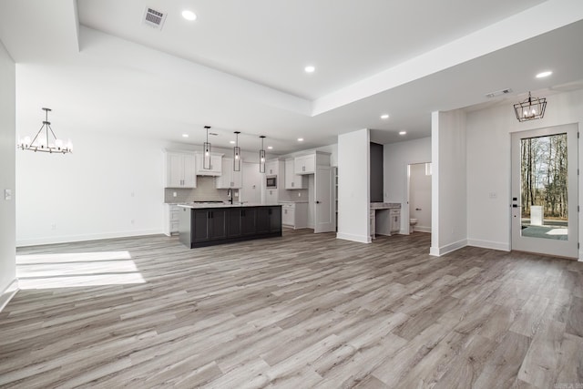 60 Estrella Way, Hot Springs Village, AR 71909 - unfurnished living room with a chandelier, recessed lighting, light wood-type flooring, and a tray ceiling