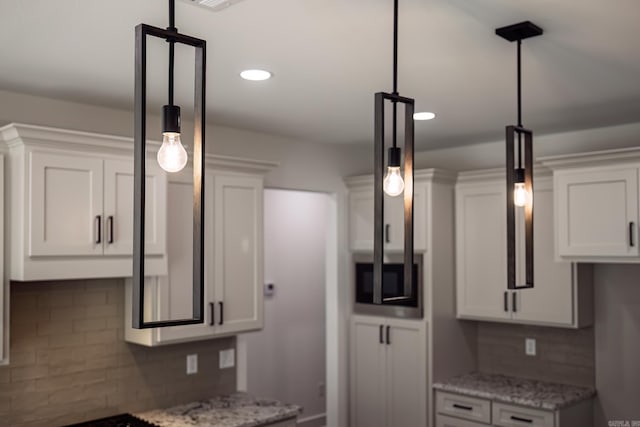 60 Estrella Way, Hot Springs Village, AR 71909 - kitchen featuring stainless steel microwave, backsplash, white cabinetry, light stone countertops, and recessed lighting