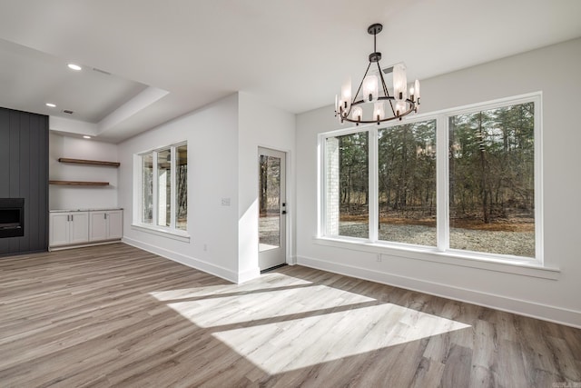 60 Estrella Way, Hot Springs Village, AR 71909 - unfurnished dining area with a chandelier, light wood finished floors, a fireplace, and recessed lighting