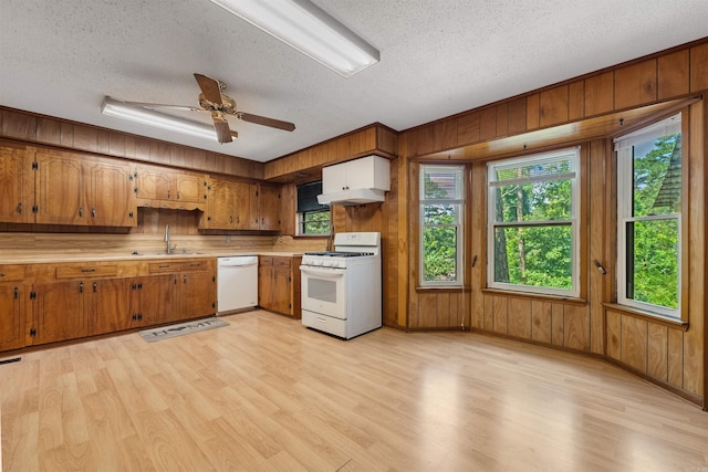 7025 Windsong, North Little Rock, AR 72113 - kitchen featuring white appliances, light countertops, a textured ceiling, wooden walls, and light wood-type flooring