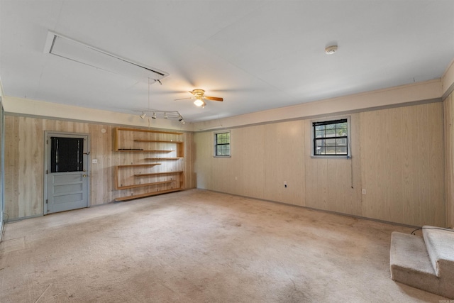 7025 Windsong, North Little Rock, AR 72113 - unfurnished living room featuring attic access, wood walls, carpet, and a ceiling fan