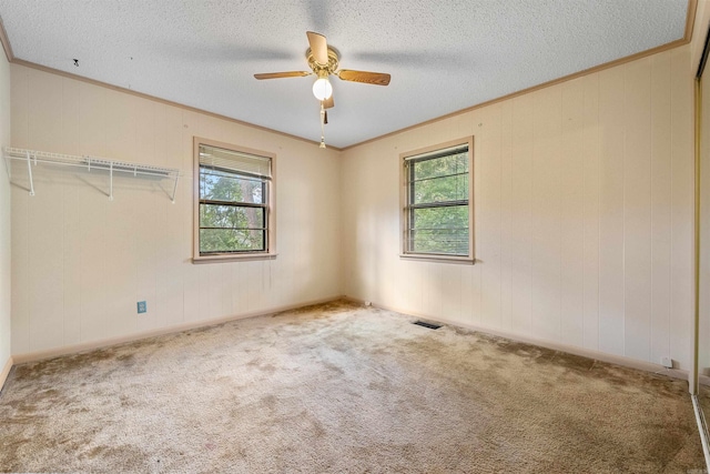 7025 Windsong, North Little Rock, AR 72113 - carpeted empty room featuring crown molding, a ceiling fan, a textured ceiling, and wood walls