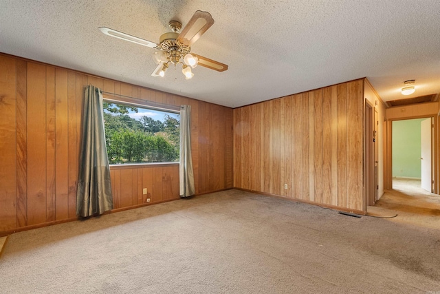 7025 Windsong, North Little Rock, AR 72113 - spare room with carpet floors, a textured ceiling, wood walls, and a ceiling fan