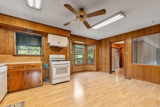 7025 Windsong, North Little Rock, AR 72113 - kitchen featuring white appliances, light wood-type flooring, wooden walls, a textured ceiling, and a ceiling fan