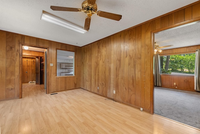7025 Windsong, North Little Rock, AR 72113 - spare room with ceiling fan, a textured ceiling, wood walls, and wood finished floors