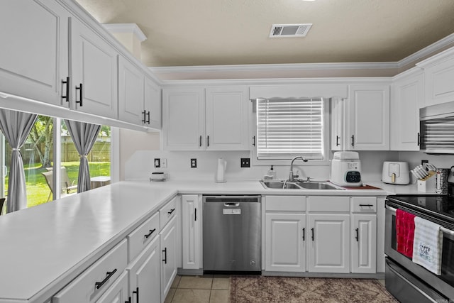 19 Mustang, Cabot, AR 72023 - kitchen featuring appliances with stainless steel finishes, white cabinetry, light countertops, light tile patterned floors, and ornamental molding