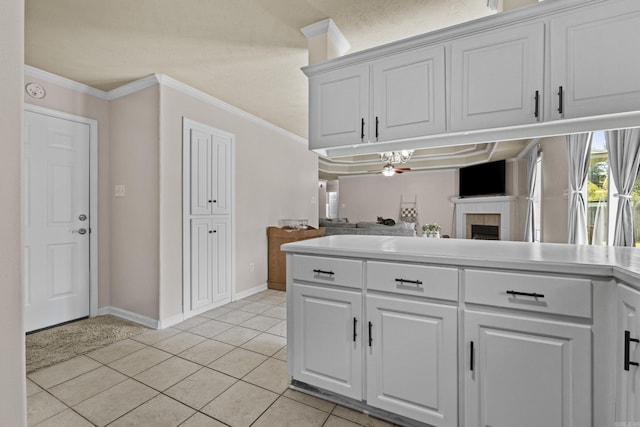 19 Mustang, Cabot, AR 72023 - kitchen featuring a tile fireplace, open floor plan, white cabinetry, and crown molding