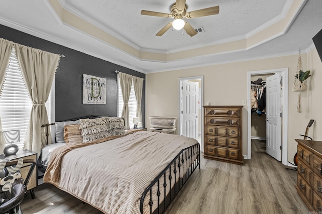 19 Mustang, Cabot, AR 72023 - bedroom featuring a raised ceiling, wood finished floors, a spacious closet, crown molding, and a closet