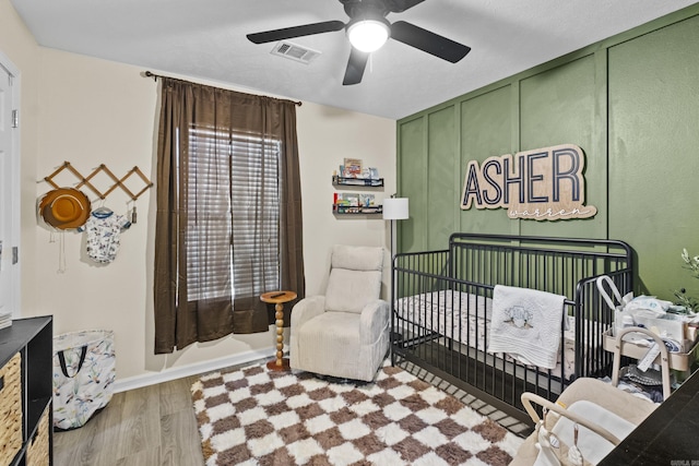 19 Mustang, Cabot, AR 72023 - bedroom with a crib, wood finished floors, and a ceiling fan