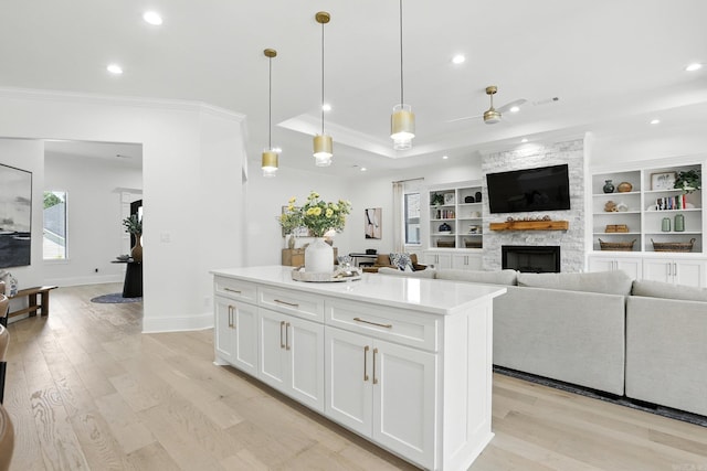 153 Caurel Cir, Little Rock, AR 72223 - kitchen with crown molding, recessed lighting, a fireplace, white cabinets, and a kitchen island