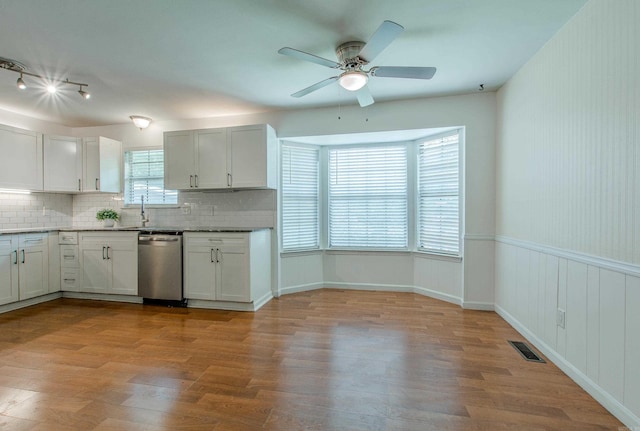 81 Stoneledge Dr, Maumelle, AR 72113 - kitchen with stainless steel dishwasher, ceiling fan, decorative backsplash, wood finished floors, and white cabinets