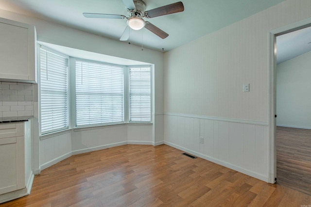 81 Stoneledge Dr, Maumelle, AR 72113 - unfurnished dining area featuring light wood-style floors, ceiling fan, and wainscoting