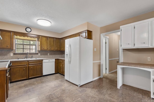 12605 Janelle Ct, Little Rock, AR 72205 - kitchen featuring white appliances, a textured ceiling, brown cabinetry, light countertops, and decorative backsplash
