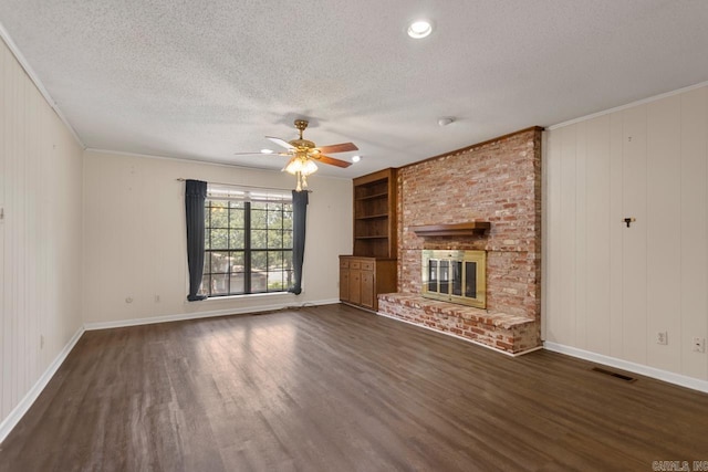12605 Janelle Ct, Little Rock, AR 72205 - unfurnished living room featuring dark wood finished floors, a textured ceiling, built in shelves, ceiling fan, and a brick fireplace