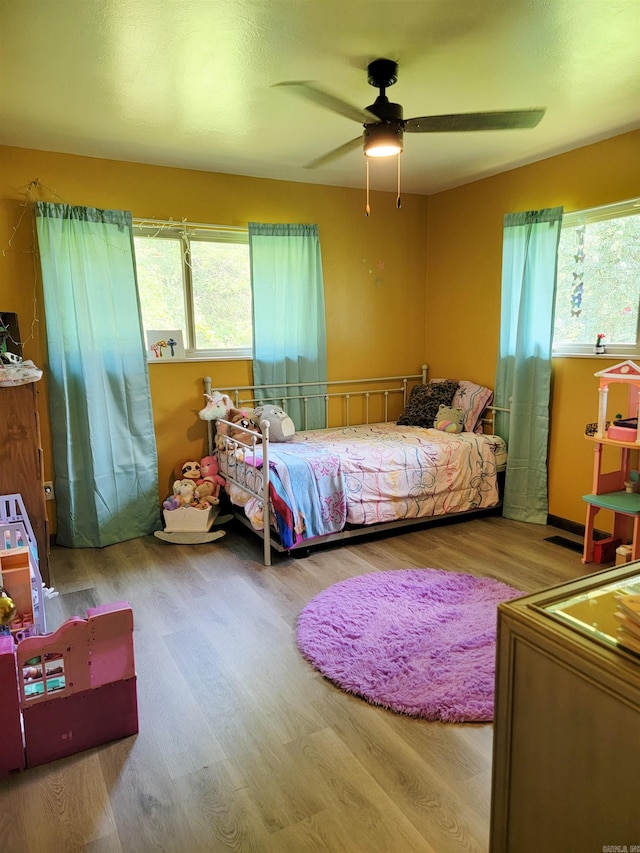 1209 Cole Ave, Mena, AR 71953 - bedroom with multiple windows, wood finished floors, and ceiling fan