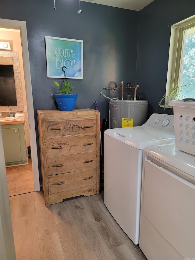 1209 Cole Ave, Mena, AR 71953 - washroom featuring washing machine and clothes dryer, light wood-style floors, and water heater