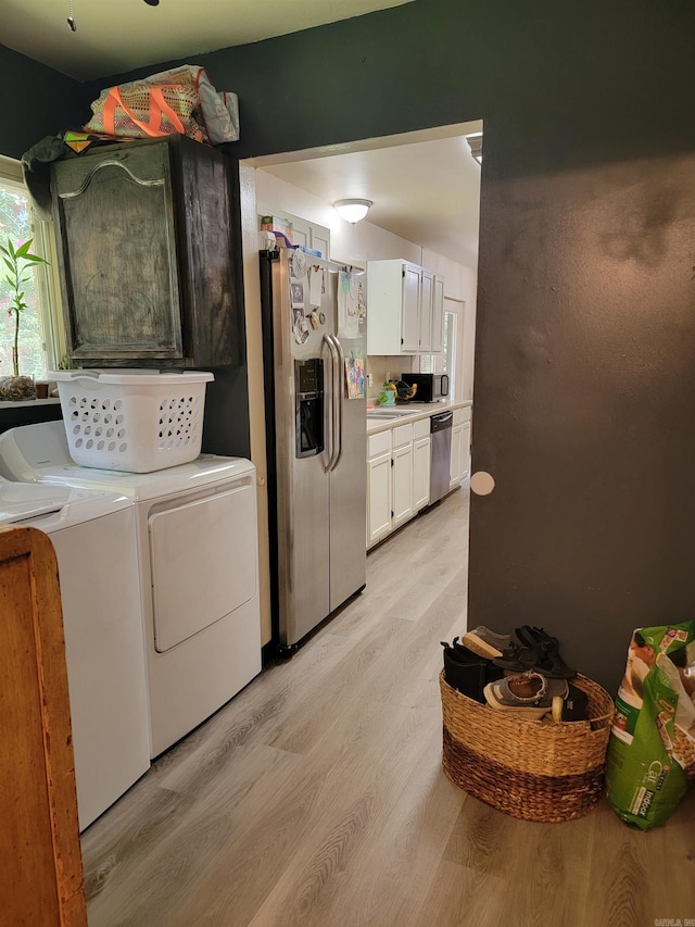 1209 Cole Ave, Mena, AR 71953 - laundry room featuring washing machine and dryer and light wood finished floors