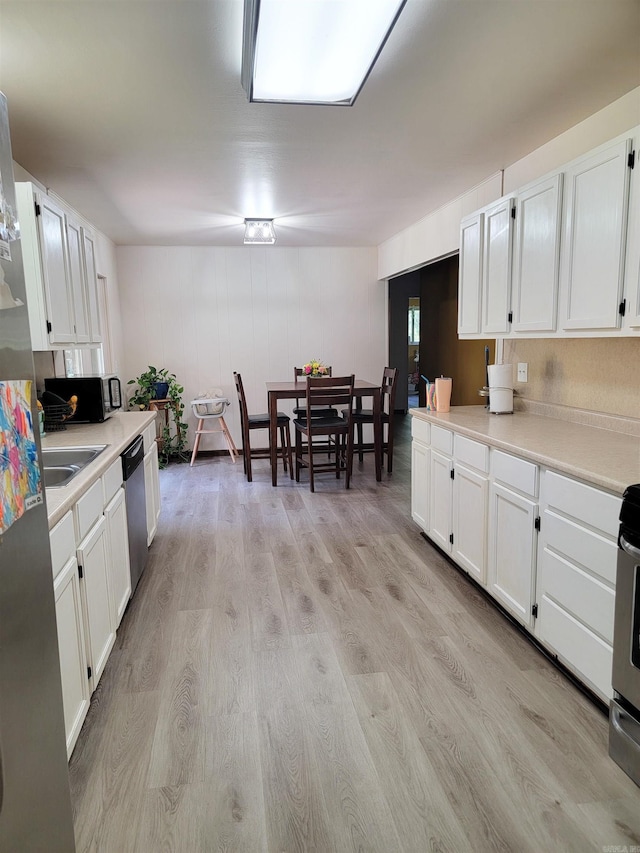 1209 Cole Ave, Mena, AR 71953 - kitchen with white cabinets, light countertops, light wood-style floors, and dishwasher