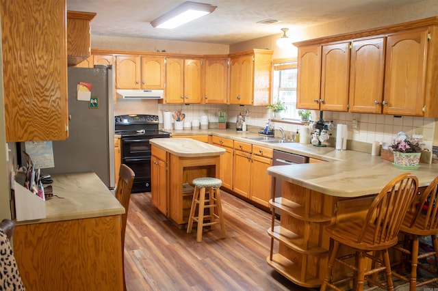 85 Linder Rd, Greenbrier, AR 72058 - kitchen with appliances with stainless steel finishes, under cabinet range hood, light wood-type flooring, a breakfast bar area, and light countertops