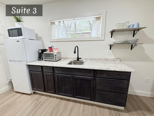 263 Jimmy Driftwood Pkwy, Mountain View, AR 72560 - kitchen with white appliances, light wood-style flooring, open shelves, and light stone countertops