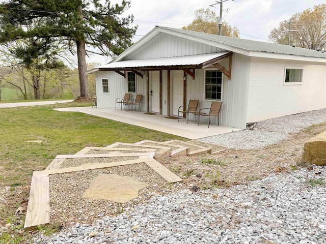 263 Jimmy Driftwood Pkwy, Mountain View, AR 72560 - back of property featuring covered porch, concrete block siding, a yard, and a metal roof