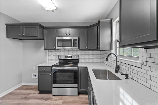 2002 Reagan Cv, Alexander, AR 72002 - kitchen featuring appliances with stainless steel finishes, light countertops, decorative backsplash, and light wood-style floors
