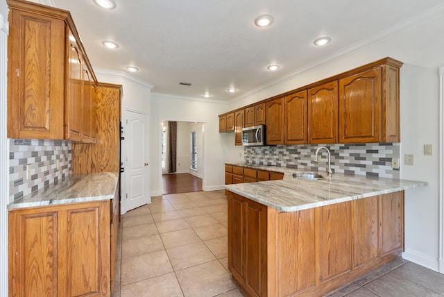 930 Enderlin, Conway, AR 72034 - kitchen featuring stainless steel microwave, a peninsula, brown cabinets, light stone countertops, and crown molding